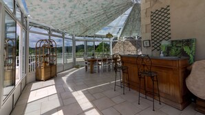 A sunlit room with a glass ceiling, wooden furniture, and a view of greenery. - Guest Room in Vignols (Vignols)