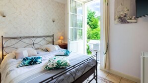 A bedroom with a bed, a nightstand, a window, and a wall-mounted TV. - Guest Room in Vignols (Vignols)