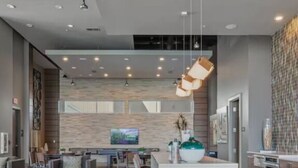 A modern hotel lobby with a central island, seating area, and a patterned wall. - Toast to the City/ ATL High-Rise with Bar & Views (Atlanta)