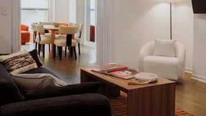 Un salon moderne comprenant un canapé, une table basse et un coin repas avec des chaises et une table.