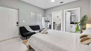 Une chambre d’hôtel moderne équipée d’un lit, d’un canapé, d’un bureau et d’un miroir.