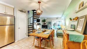 Una cucina con tavolo e sedie in legno e un frigorifero in acciaio inossidabile.