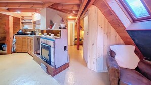 A cozy cabin interior with a kitchen area, a fireplace, and a skylight. - Chalet BomBom - Cozy cocoon with pond view in Mittlach (Mittlach)