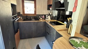 A compact kitchen with a built-in oven, a sink, and a window.