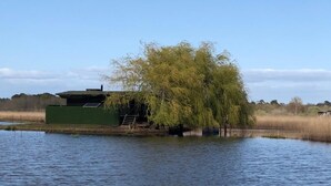 A house by a lake with a weeping willow tree in front. - In the midst of wildlife and marshland, a ton of thrills and chills  (Vendays-Montalivet)