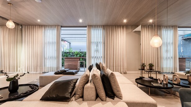 En moderne stue med sofa, sofabord og spiseplads.
