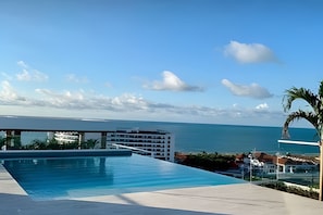 A swimming pool with a view of the ocean and a building in the background. - 808 Martinique (Cartagena)
