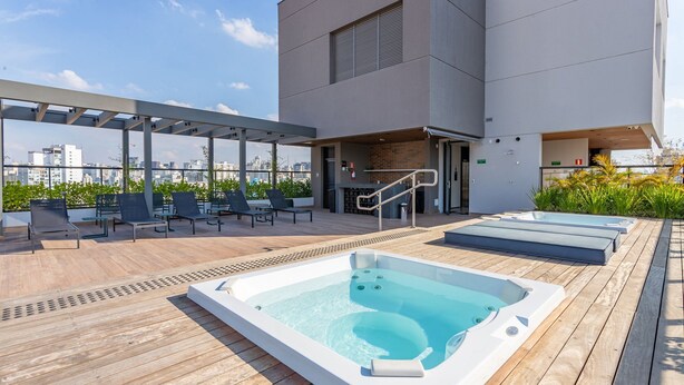A rooftop pool area with hot tubs, lounge chairs, and a covered seating area. - ISC - Well-located Studios in Vila Buarque, Sao Paulo (São Paulo)