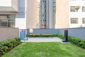 A courtyard with a bench, a gate, and a building with multiple windows. - ISC - Well-located Studios in Vila Buarque, Sao Paulo (São Paulo)