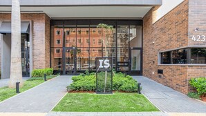 A modern building entrance with a brick facade, a glass door, and a sign with 'IS' and 'CONSELAÇÃO'. - ISC - Well-located Studios in Vila Buarque, Sao Paulo (São Paulo)