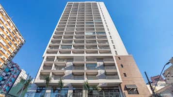 A tall, modern building with multiple balconies and a sign reading "seazone".