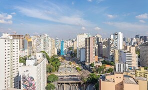 A cityscape with high-rise buildings, a central road, and a mural on a building. - ISC - Well-located Studios in Vila Buarque, Sao Paulo (São Paulo)