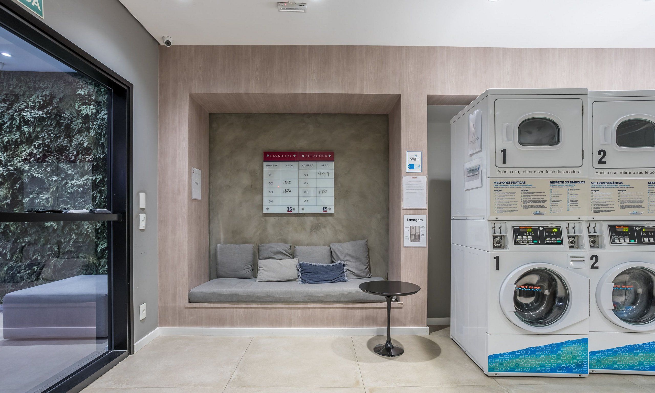 A laundry area with a seating area, a wall-mounted calendar, and a washing machine.