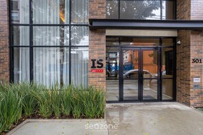 A building entrance with glass doors, a brick facade, and a sign reading "301". - Modern Studio 450m From the Subway Ism0806 (São Paulo)