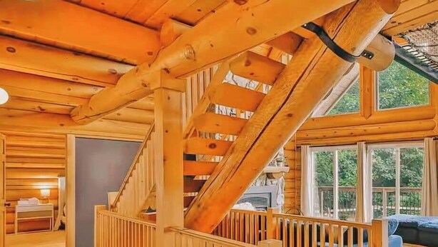 A wooden staircase with a railing leading to a second-floor area.