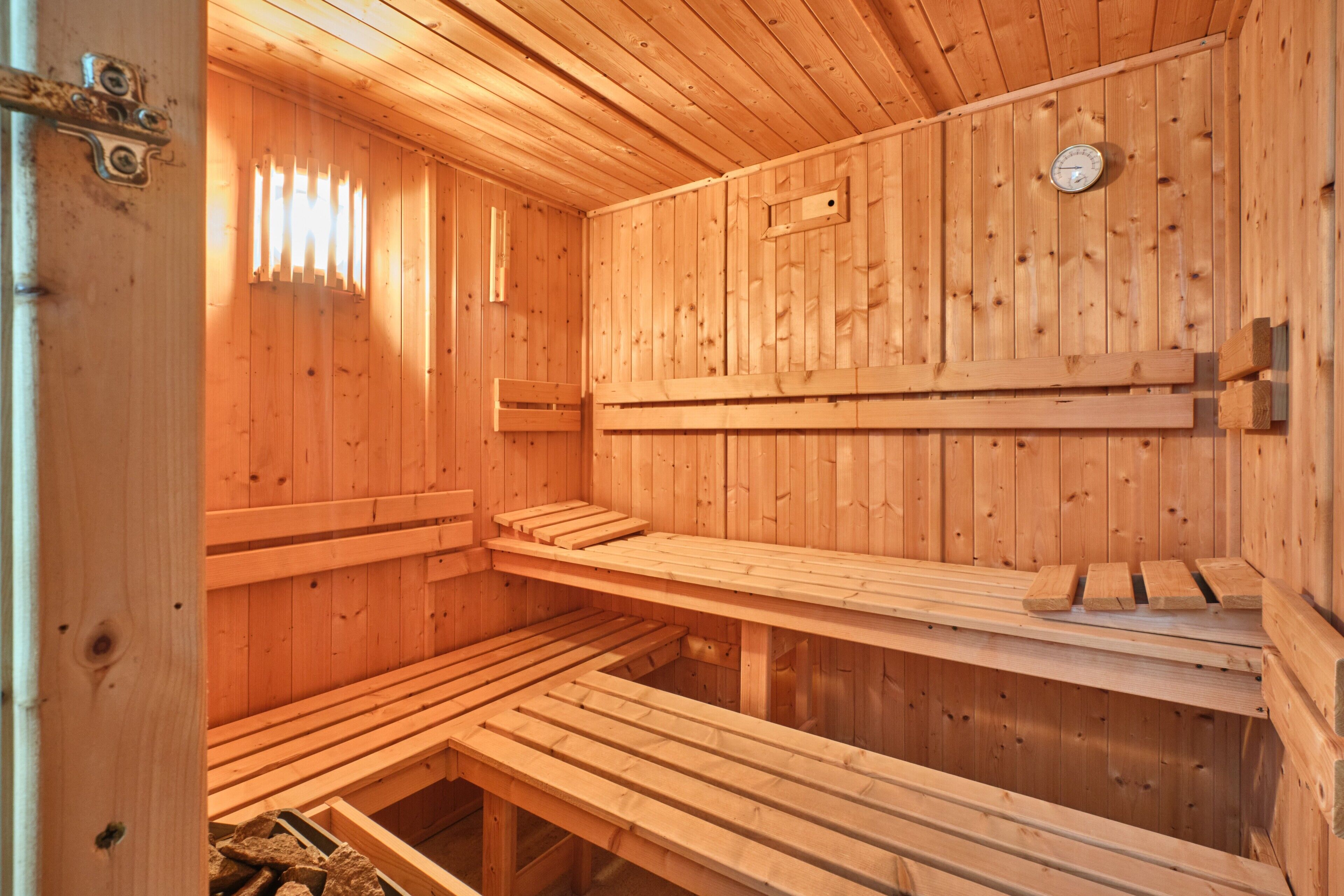 Eine Holzsauna mit Bänken und einem Wandofen.
