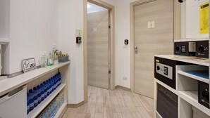 A hotel corridor with a reception area, a door, and a wall-mounted security camera. - Room 'Tripla' with Wi-Fi and Air Conditioning (Milano)