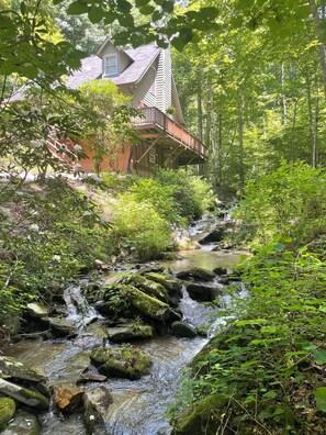A house with a wooden deck overlooking a stream. - Creekside Retreat-Close to Sylva, Cherokee, and Dillsboro (Whittier)