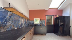 Eine moderne Küche mit Marmorfliesenspiegel, einer schwarzen Arbeitsplatte und einem eingebauten Backofen.