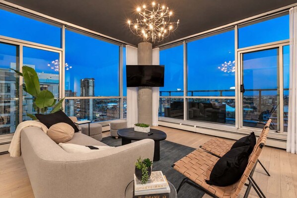 A modern living room with a sofa, a coffee table, and a TV mounted on the wall.