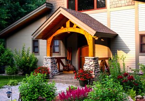 A house with a stone archway entrance, a stone pillar, and a wooden porch.