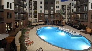 A modern hotel with a central swimming pool surrounded by lounge areas and outdoor seating. - Revive Tanglewood Stunning 2BR in Uptown Houston (Houston)