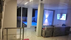 A modern interior with a staircase, a sofa, and a television. - Villa with swimming pool 7mn from port Say (Marsa Ben M'Hidi)