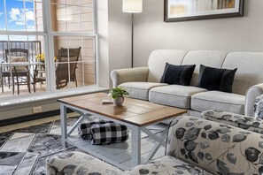 Un salon avec un canapé, une table basse et une vue sur l’extérieur.