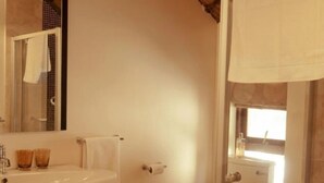 Une salle de bain équipée d’un lavabo, d’un miroir, de toilettes et d’un espace douche.