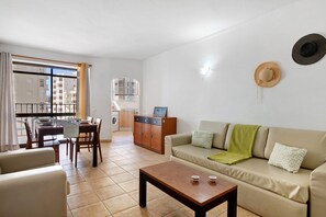 Un salon comprenant un canapé, une table basse et un coin repas avec des chaises et une table.