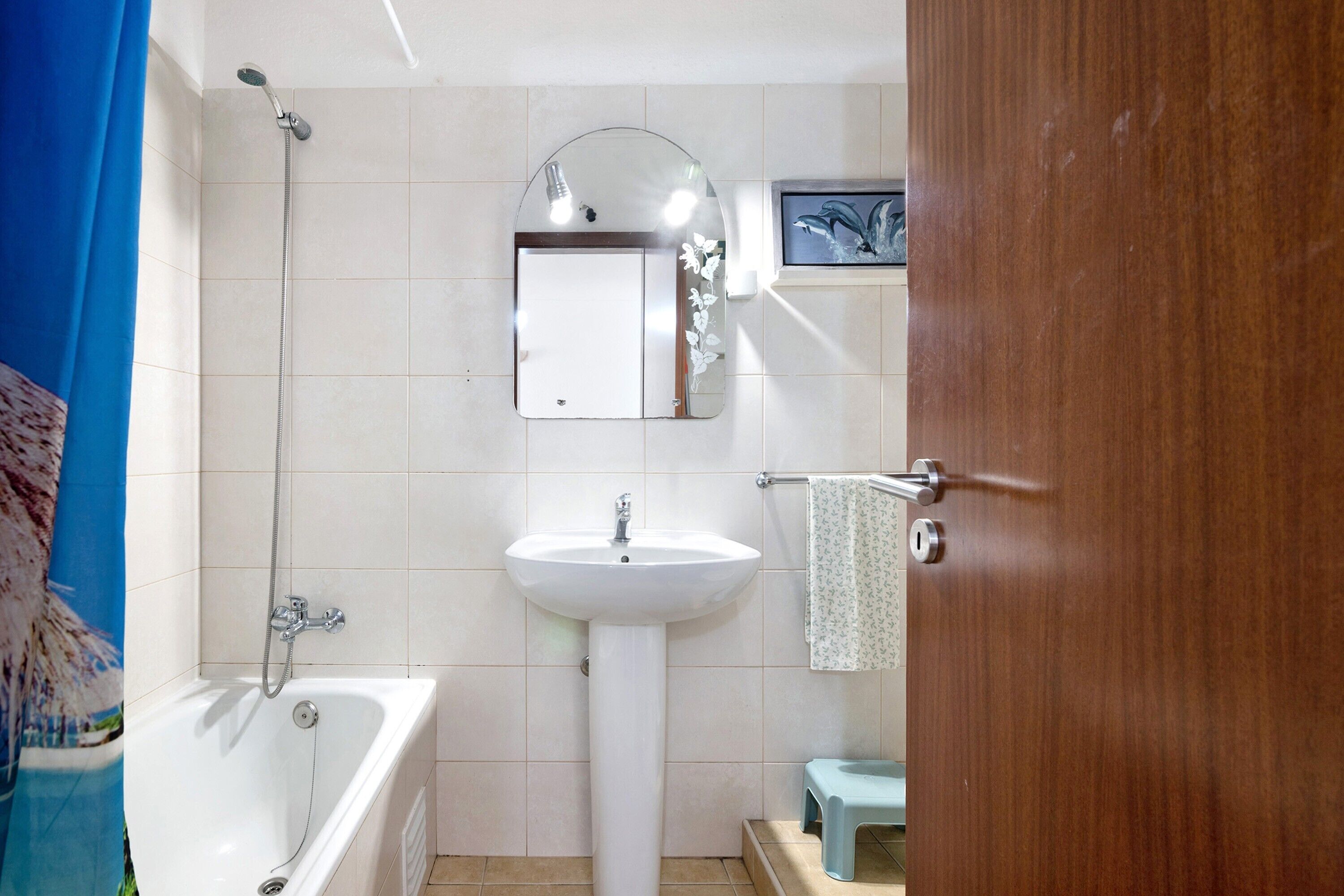 Een badkamer met een bad, een wastafel, een spiegel en een douche.