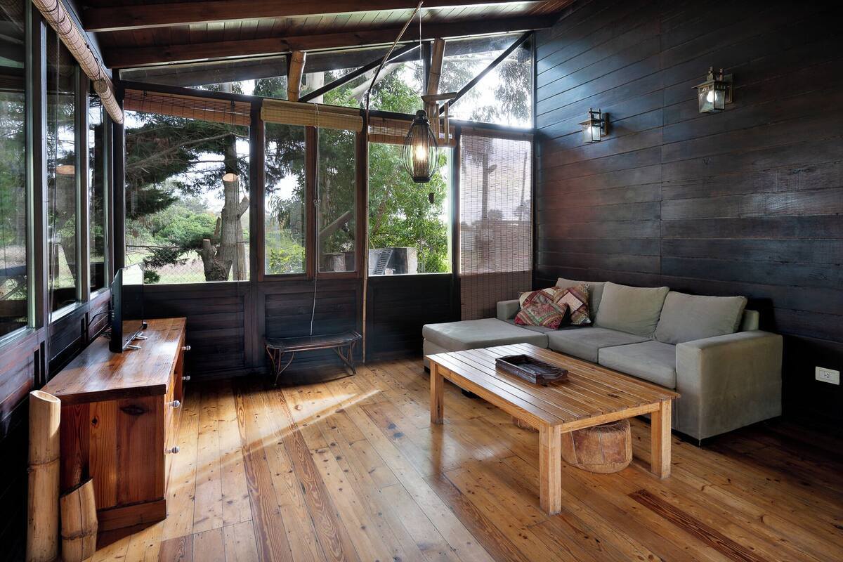 A room with a wooden bench, a sofa, and a coffee table.