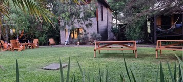 Un giardino curato con mobili in legno, un edificio in pietra e un'amaca.