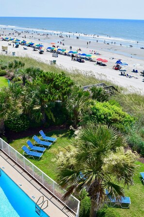 A beach resort with a swimming pool, sun loungers, and umbrellas. - Oceanfront 1BR in Myrtle Beach w/ Private Balcony (Myrtle Beach)