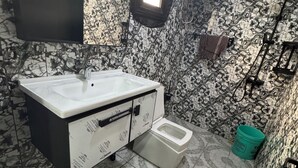 A bathroom with a marble sink, a toilet, and a shower. - 3rd floor (Conakry)