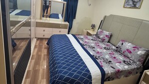 A bedroom with a bed, a dresser, a mirror, and an air conditioning unit. - 3rd floor (Conakry)