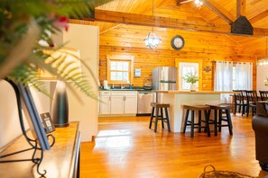 A wooden interior with a kitchen, dining area, and a bar.
