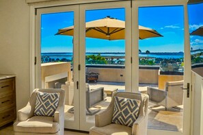 Ein Balkon mit zwei Stühlen, einem Tisch und einem großen Sonnenschirm.