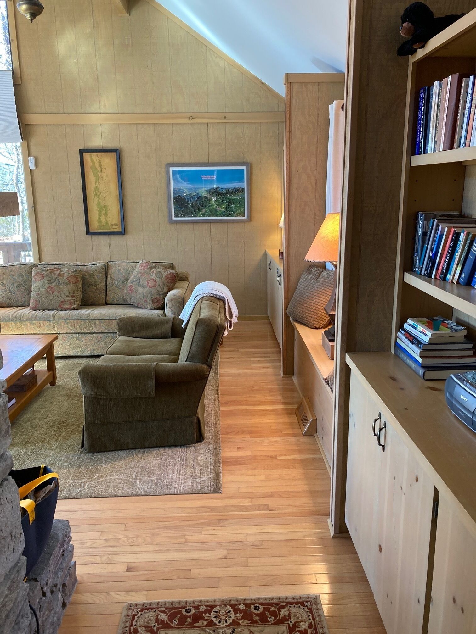 A cozy living room with a sofa, a coffee table, and a bookshelf.