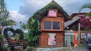 A rustic wooden building with a signboard advertising local delicacies.