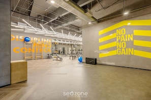 A gym with exercise equipment, a motivational wall with 'NO PAIN NO GAIN' slogan, and a 'SEAZONE' logo. - Modern Studio in Itaim Bibi-sp Cia2313 (São Paulo)