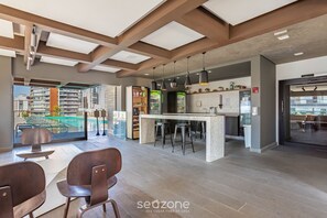 Un interior moderno con vista a la piscina, zona de bar y asientos.