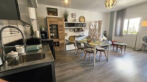 A modern kitchen with a built-in oven and a dining area with a wooden table and chairs.