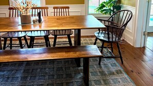 Comedor con mesa de madera, bancos y una araña.
