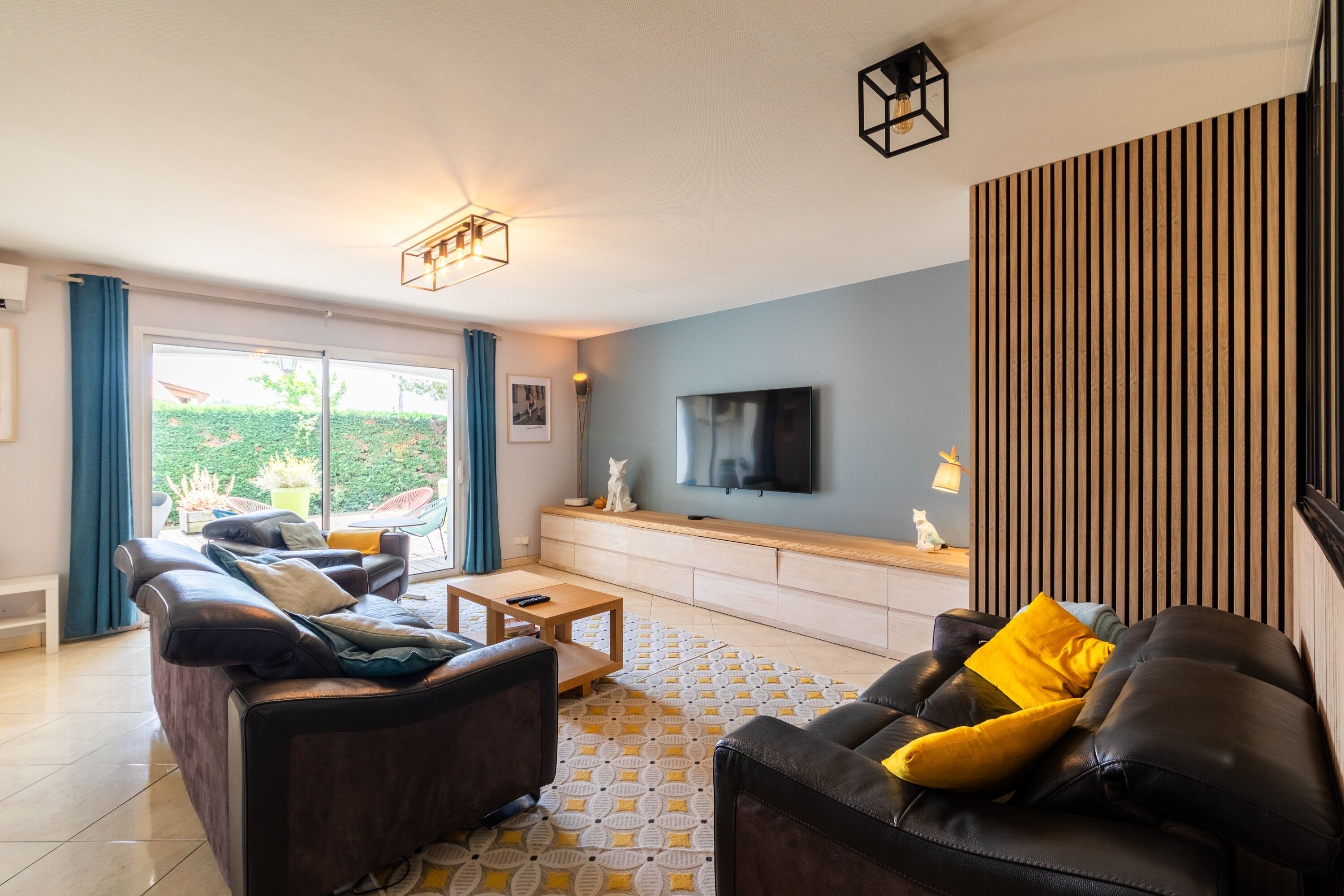 A modern living room with a sofa, a coffee table, and a TV on a wooden console.