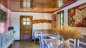 Un espace repas doté d’un plafond en bois, d’une grande carte accrochée au mur et d’une table entourée de chaises.