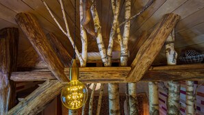 A rustic interior with wooden beams and branches forming a ceiling structure.