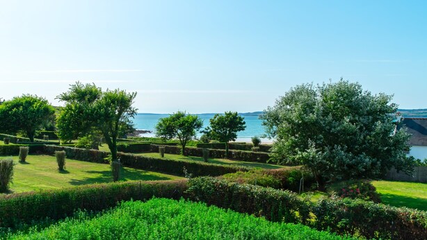 A well-maintained garden with neatly trimmed hedges and a variety of trees. - Maison HG - Presqu'ile de Crozon (Plomodiern)