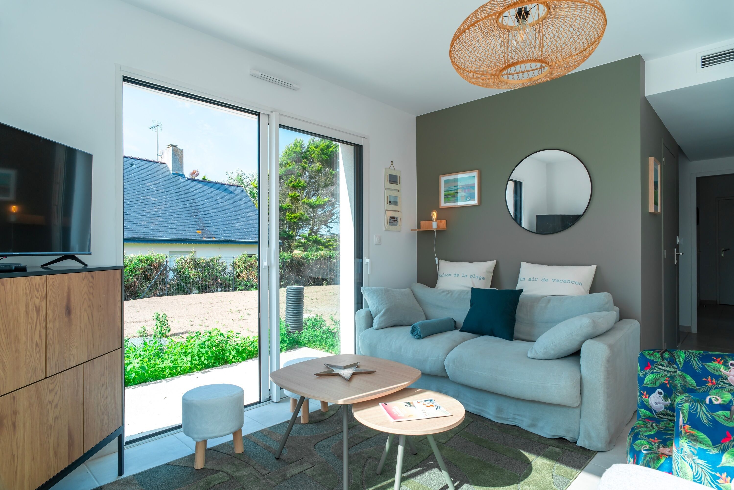 Un salon moderne avec un canapé, une petite table ronde et un téléviseur.