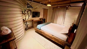 A cozy room with a wooden bed, a desk, and a TV. - Solar Kaeté (Santo Amaro do Maranhão)